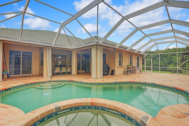 view of swimming pool with glass enclosure, an in ground hot tub, and a patio