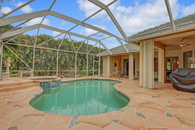 view of pool featuring glass enclosure, an in ground hot tub, a patio, and ceiling fan