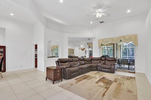 tiled living room with a towering ceiling and ceiling fan