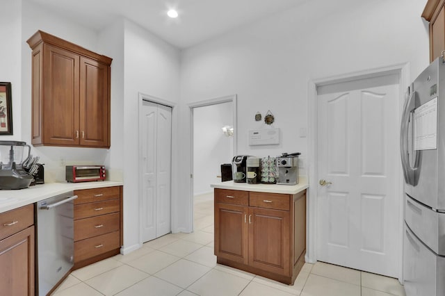 kitchen featuring washer / clothes dryer, appliances with stainless steel finishes, and light tile patterned flooring