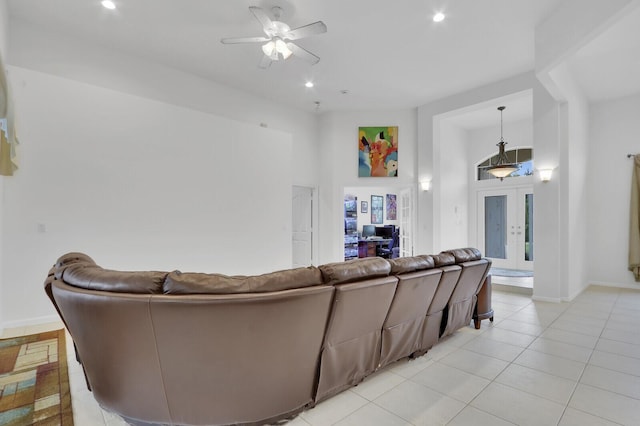 tiled living room featuring ceiling fan and french doors