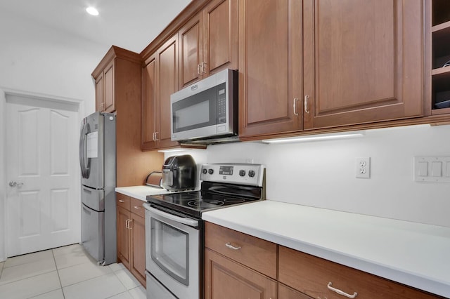 kitchen with light tile patterned floors and stainless steel appliances