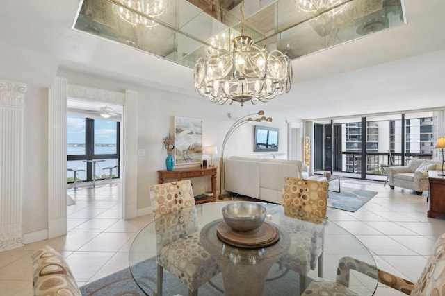 tiled dining area featuring a healthy amount of sunlight and ceiling fan with notable chandelier