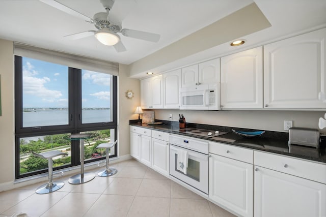 kitchen featuring white cabinetry, ceiling fan, white appliances, and light tile patterned floors