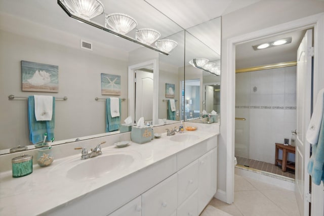 bathroom with dual vanity, a shower with shower door, and tile patterned flooring