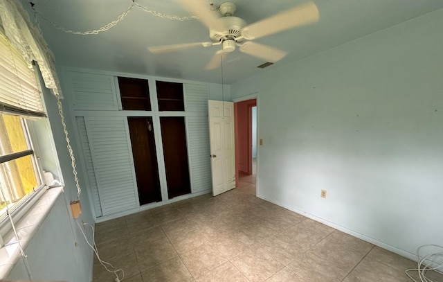 unfurnished bedroom featuring ceiling fan and a closet