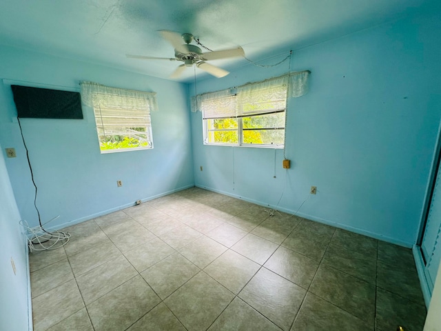 tiled spare room featuring ceiling fan