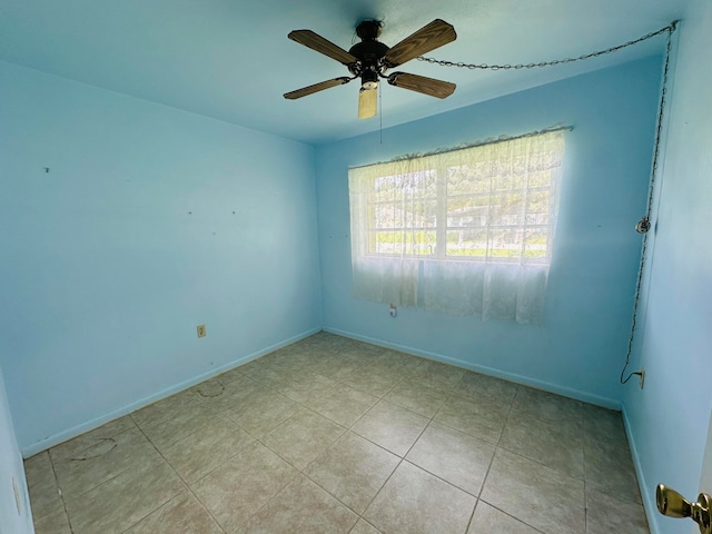 tiled spare room featuring ceiling fan