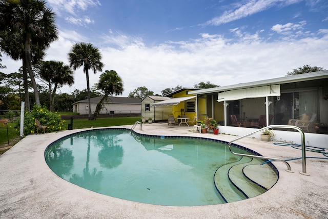 view of swimming pool featuring a sunroom and a patio