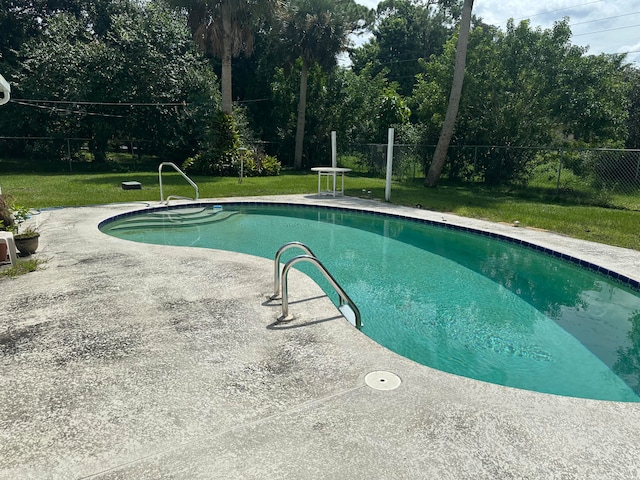 view of pool featuring a lawn