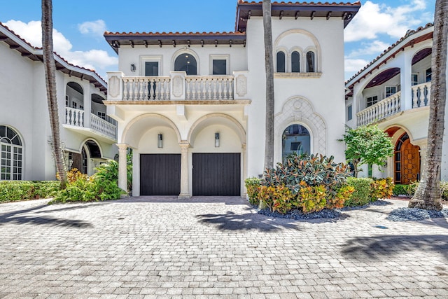 mediterranean / spanish house with a garage and a balcony