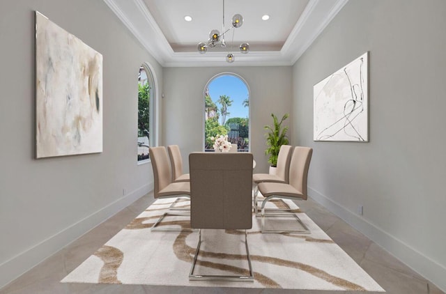 dining area with a raised ceiling and ornamental molding