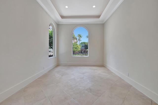 tiled empty room with a healthy amount of sunlight and a tray ceiling