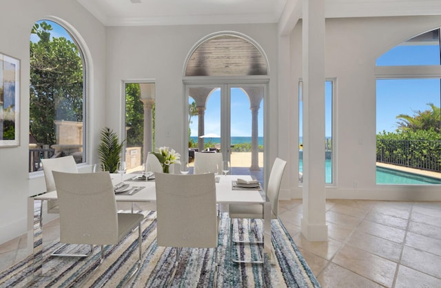 tiled dining space with ornamental molding and plenty of natural light