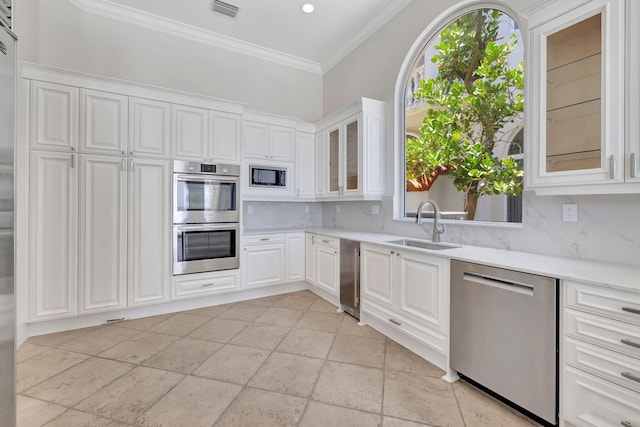 kitchen with sink, decorative backsplash, stainless steel appliances, and white cabinets