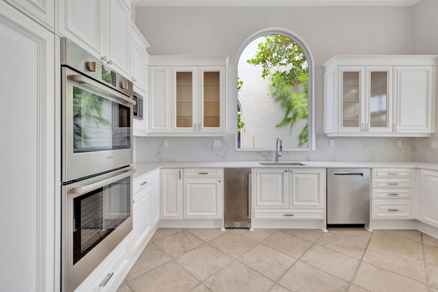 kitchen with sink, ornamental molding, stainless steel appliances, and backsplash