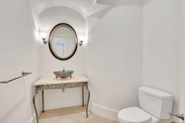 bathroom with toilet, tile patterned flooring, and sink