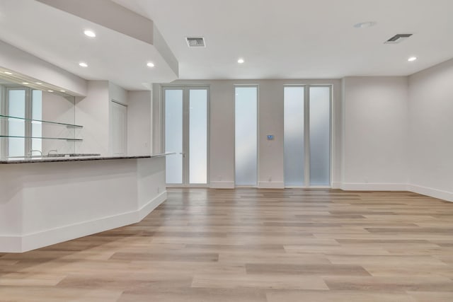 unfurnished living room with a wealth of natural light and light wood-type flooring