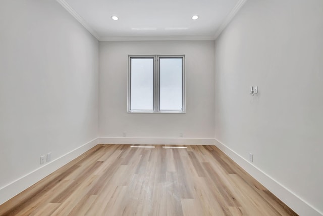 empty room featuring ornamental molding and light wood-type flooring