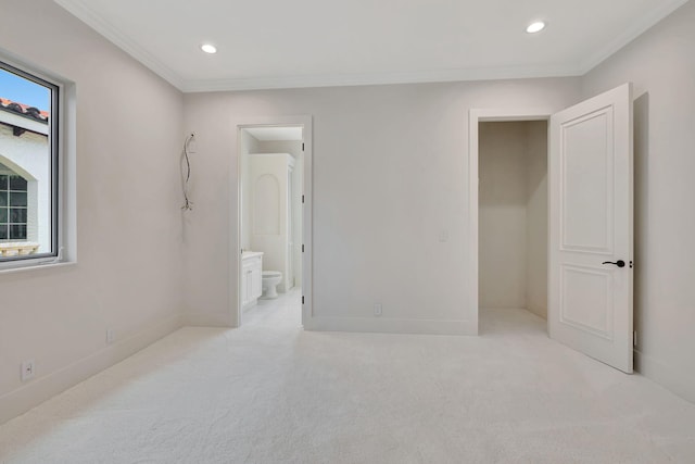 bedroom with light colored carpet, ensuite bathroom, and ornamental molding