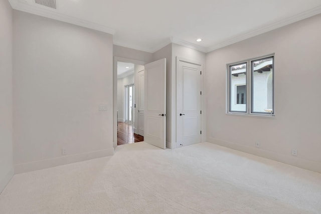 empty room with crown molding and carpet floors