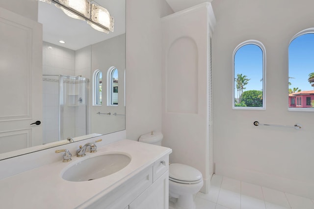 bathroom with a healthy amount of sunlight, toilet, an enclosed shower, and vanity