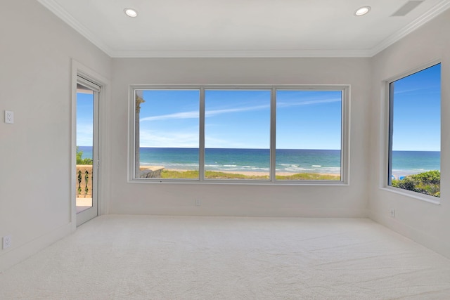 carpeted empty room featuring a water view and crown molding