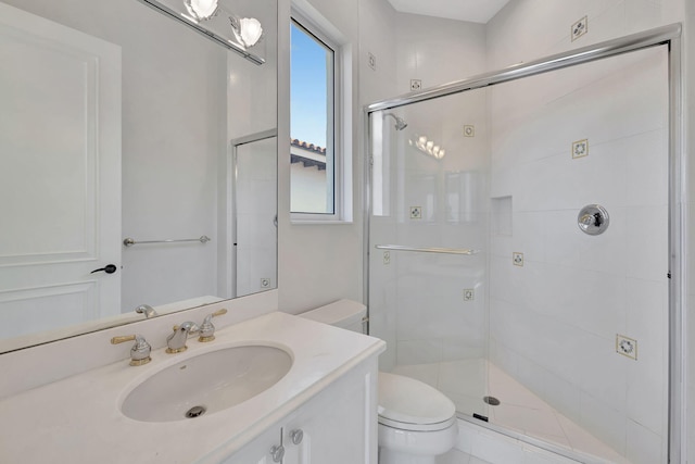 bathroom with a shower with shower door, vanity, and toilet