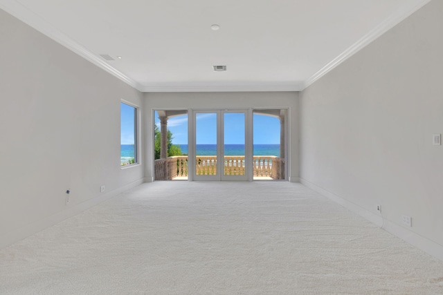 carpeted empty room with ornamental molding and a water view