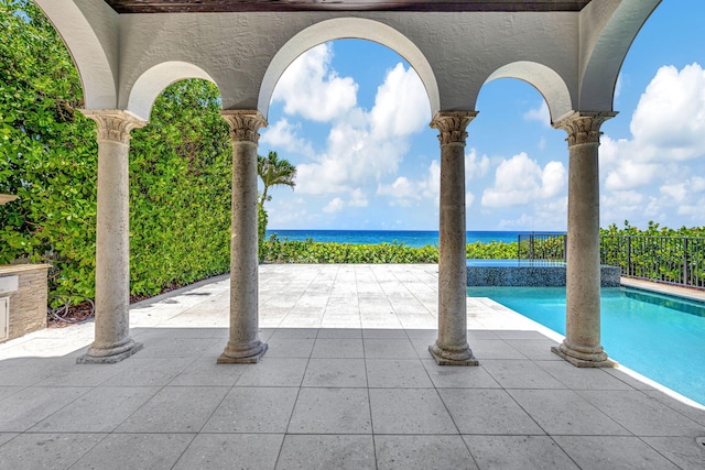 view of pool featuring a water view and a patio area