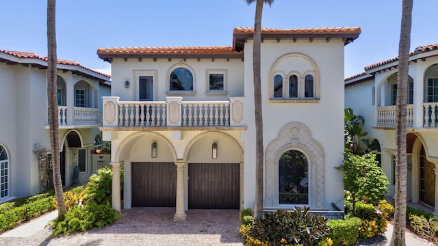 mediterranean / spanish-style home featuring a balcony and a garage