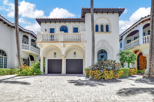 mediterranean / spanish-style home with a garage and a balcony