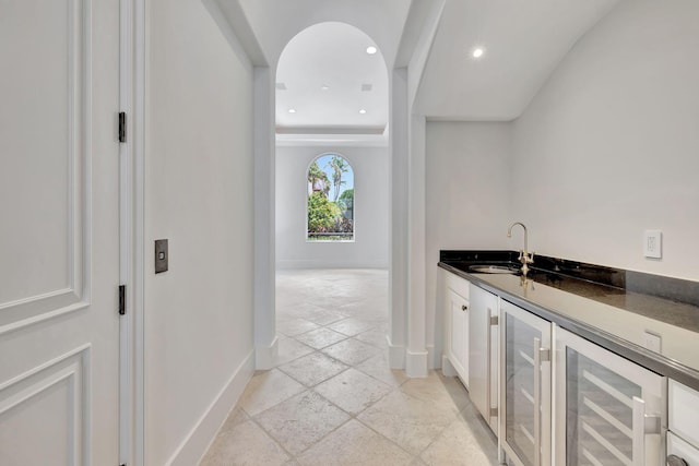 bar featuring crown molding, light tile patterned floors, wine cooler, white cabinets, and sink