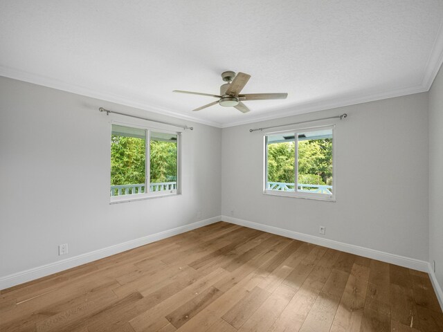 empty room featuring light wood-type flooring, ceiling fan, and crown molding