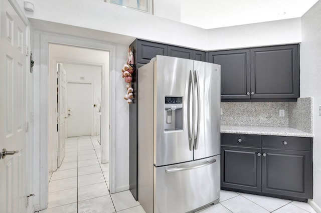 kitchen featuring decorative backsplash, stainless steel fridge, and light tile patterned floors