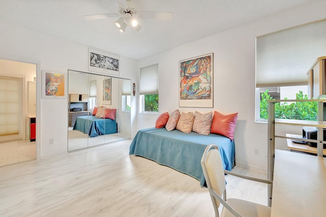 bedroom featuring light wood-type flooring, a closet, and ceiling fan