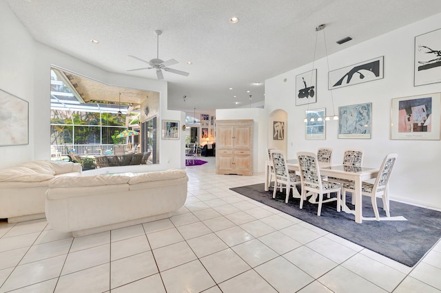 tiled living room featuring ceiling fan and a textured ceiling