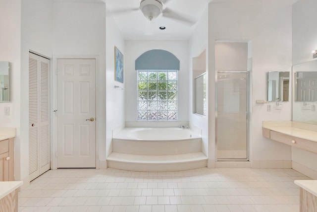 bathroom featuring plus walk in shower, vanity, and tile patterned flooring