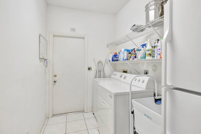 laundry area with separate washer and dryer and light tile patterned flooring