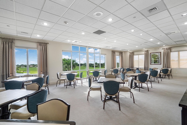 carpeted dining space featuring a paneled ceiling