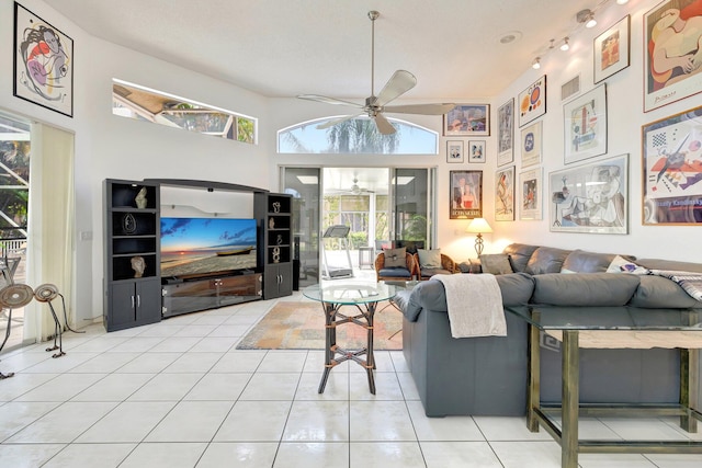 living room with ceiling fan, light tile patterned floors, and a towering ceiling