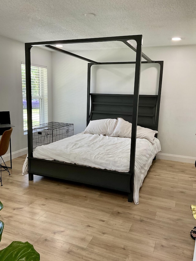 bedroom featuring a textured ceiling and light wood-type flooring