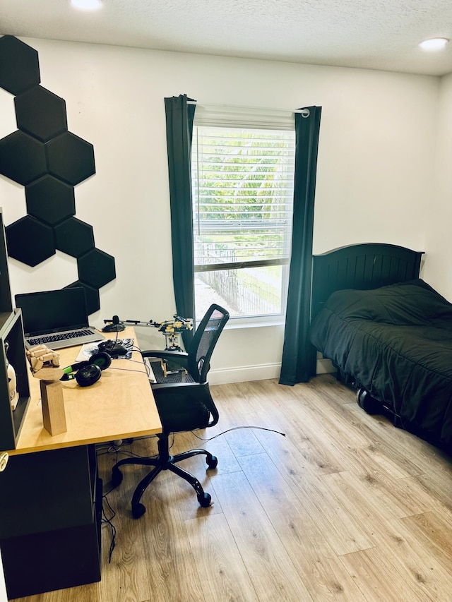 office featuring plenty of natural light, a textured ceiling, and light hardwood / wood-style flooring