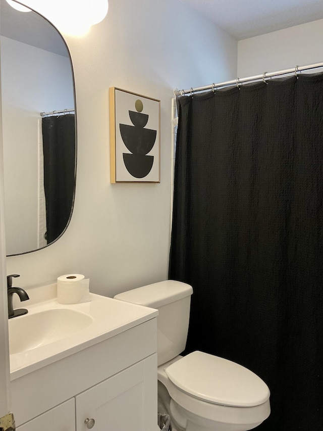 bathroom with vanity, curtained shower, and toilet