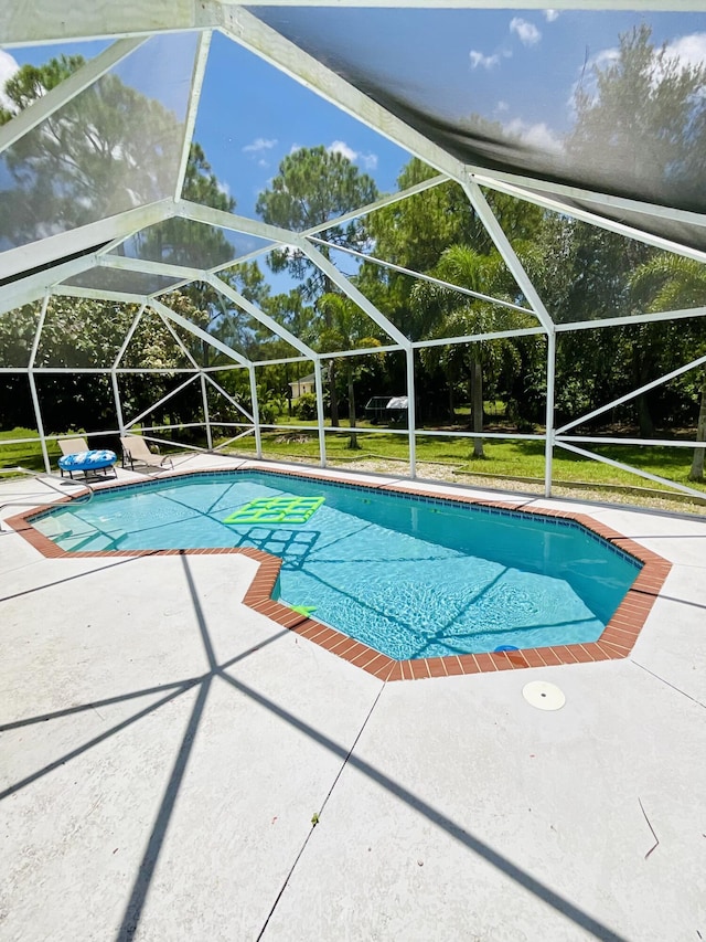 view of swimming pool with a lanai, a patio area, and a yard