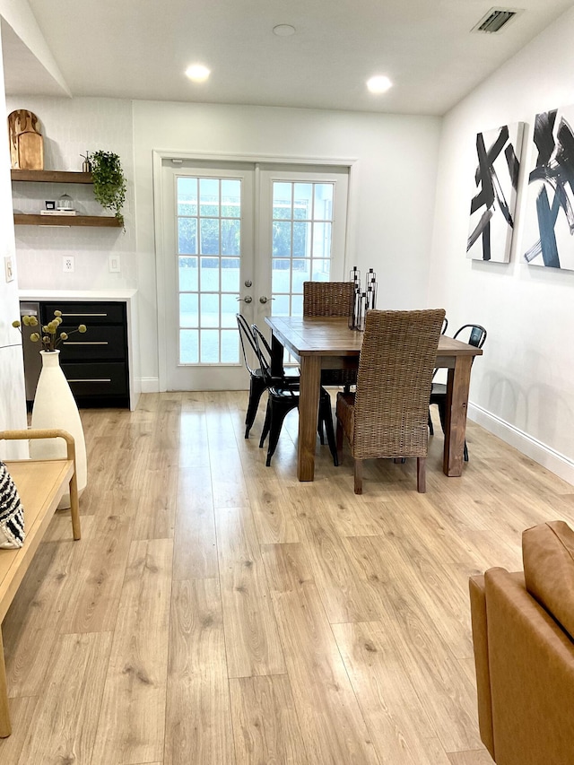 dining space featuring light wood-type flooring and french doors