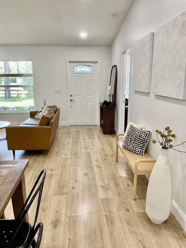 foyer with light hardwood / wood-style floors and vaulted ceiling