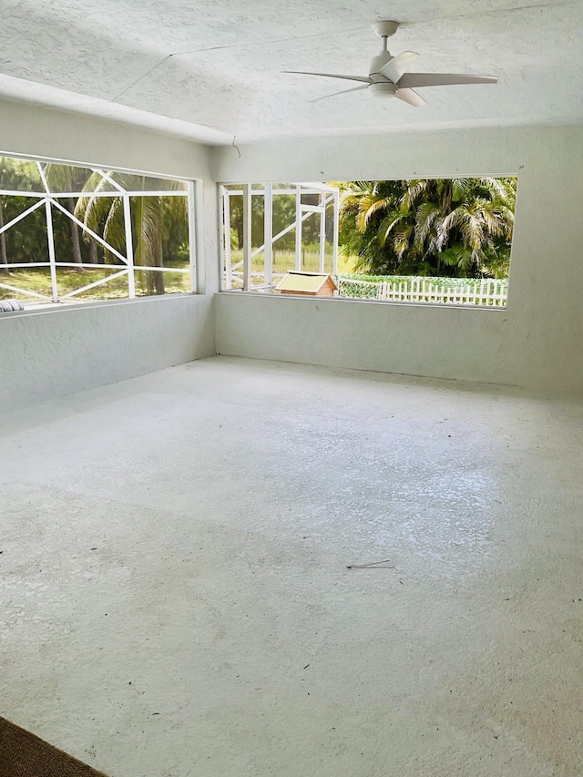 unfurnished sunroom with ceiling fan