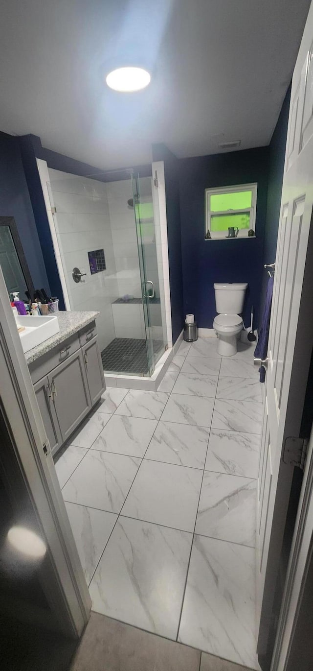 bathroom featuring an enclosed shower, vanity, and toilet