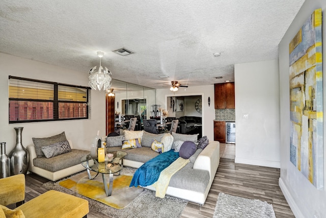 living room featuring ceiling fan, a textured ceiling, and hardwood / wood-style flooring